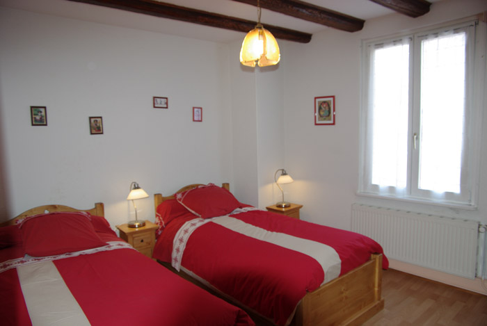 A smart two-person bedroom with two beds one person, furniture in oak, apparent beams