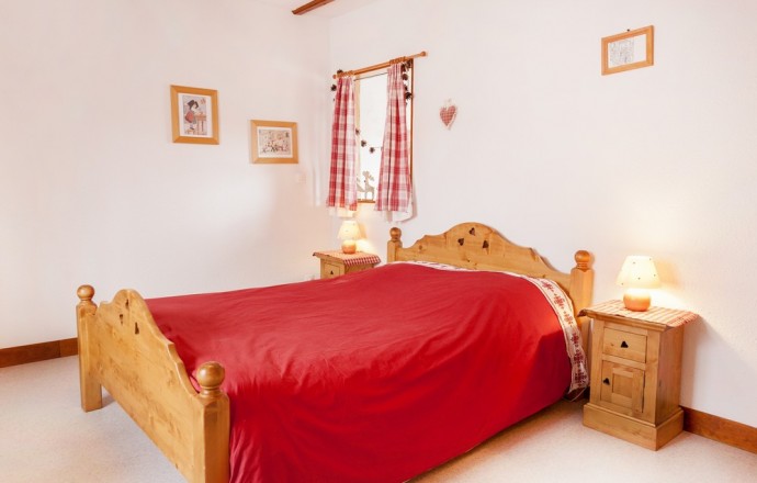 Chambre avec lit 140x190,  poutres apparentes, meuble en sapin,  couette douillette et gravures Hansi